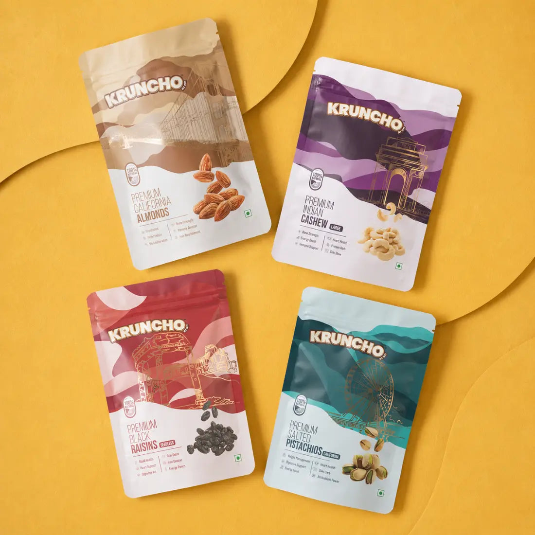 A 4-in-1 combo set of Kruncho dry fruit pouches featuring California Almonds, Indian Cashews, Seedless Black Raisins, and California Salted Pistachios arranged on a yellow background.