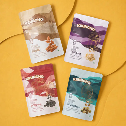 A 4-in-1 combo set of Kruncho dry fruit pouches featuring California Almonds, Indian Cashews, Seedless Black Raisins, and California Salted Pistachios arranged on a yellow background.