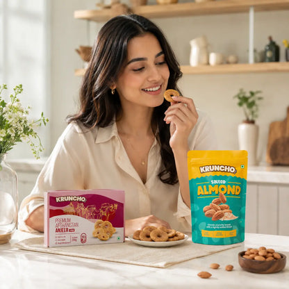 Woman eating Kruncho Premium Afghanistan Jumbo Anjeer and Salted Almonds for a healthy daily snack routine.