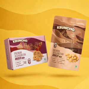 Kruncho Premium Afghanistan Anjeer 250g box alongside a pack of Kruncho Premium Afghanistan Apricot Jumbo on a yellow background.