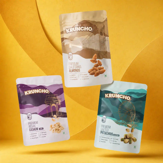 Three Kruncho dry fruit pouches - Premium California Almonds, Premium Indian Cashews, and Premium Salted Pistachios - floating over a vibrant yellow backdrop.